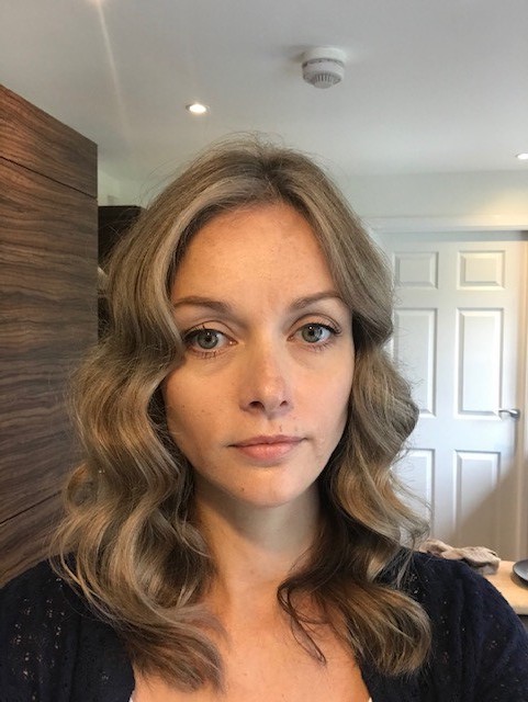 A woman with wavy brown hair.