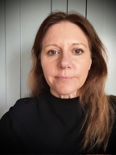 Image of a woman with long brown hair wearing a black turtleneck top