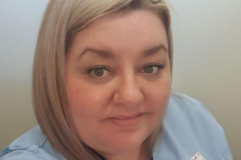 A nurse in a blue uniform.