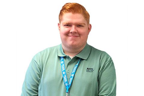 A red haired person wearing a green tshirt.