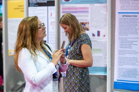 Women taking notes while looking at poster