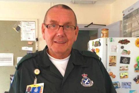 A man in green paramedics uniform.