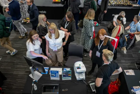 Overhead view of people talking around a display table