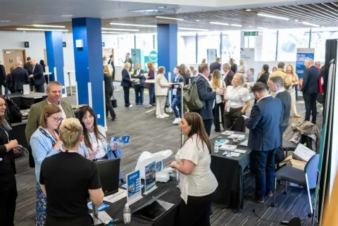 Many people in a large room talking in small groups.