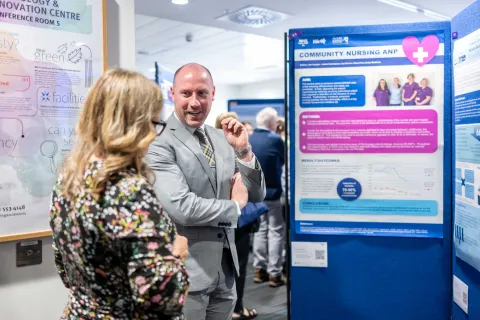 People standing by a poster board