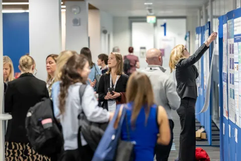 Many people wandering through poster displays