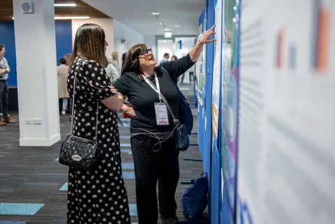 Two people discussing a poster display