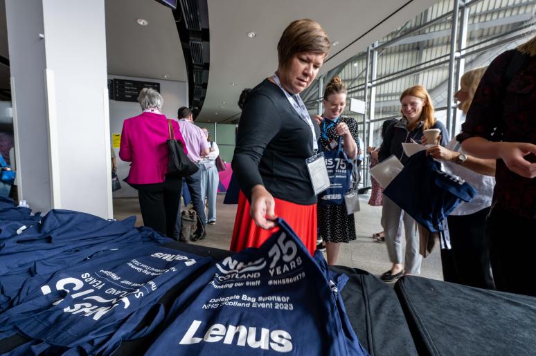 Event attendees entering the building, collecting merchandise from a table