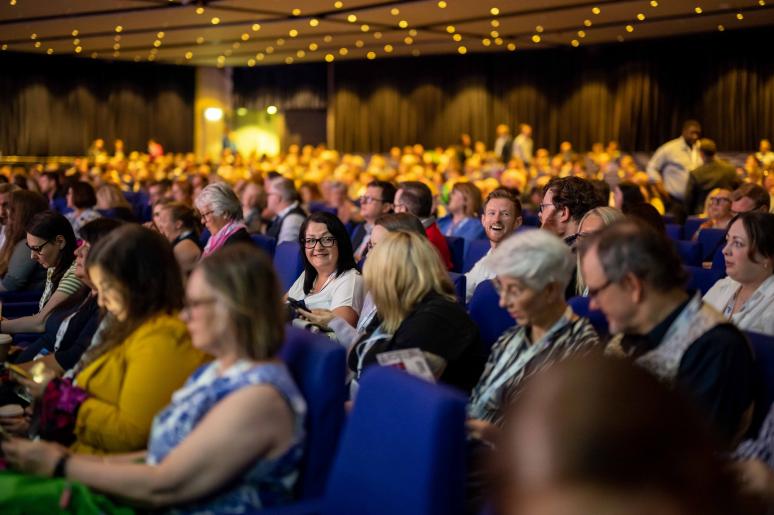 A large group of event attendees watching a presentation