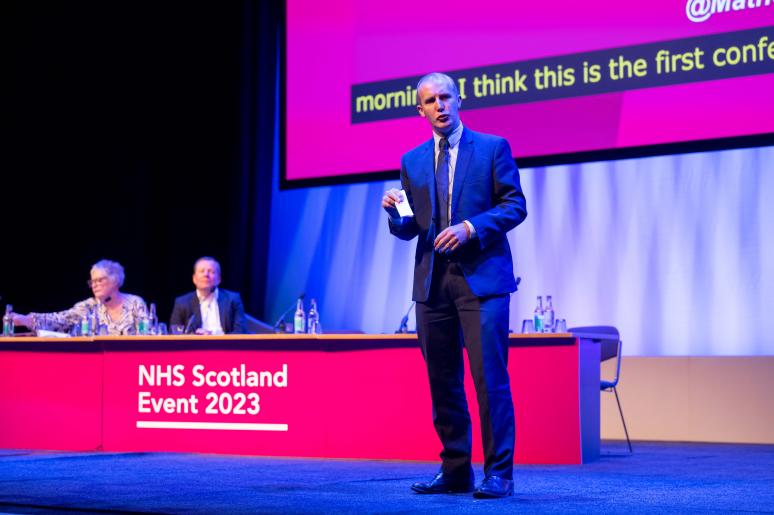 A speaker delivering a presentation on the main stage