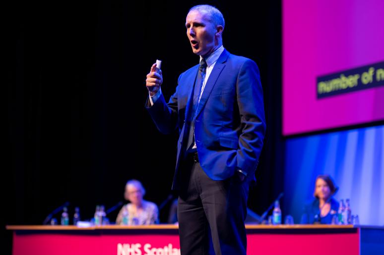 A speaker delivering a presentation on the main stage