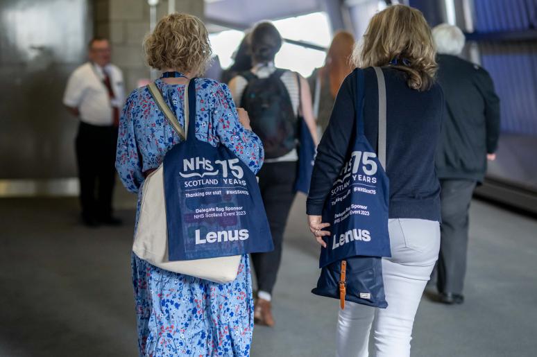 Event attendees entering the main event space with their NHS Scotland tote bags
