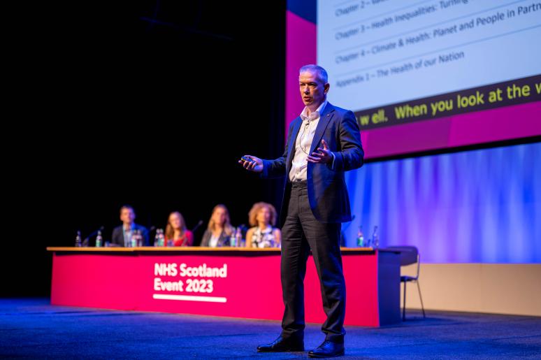 A speaker delivering a presentation on the main stage