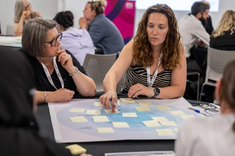 Two event attendees sitting at a table during a workshop
