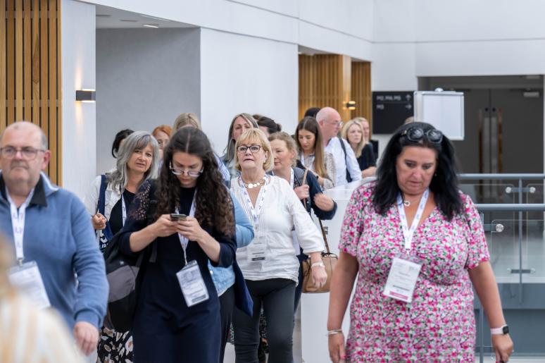 A small group of event attendees walking into a presentation