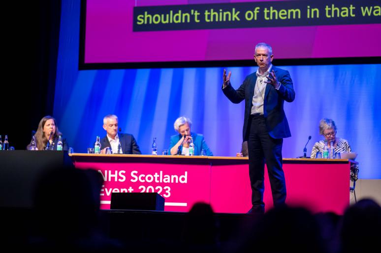 A speaker delivering a presentation on the main stage