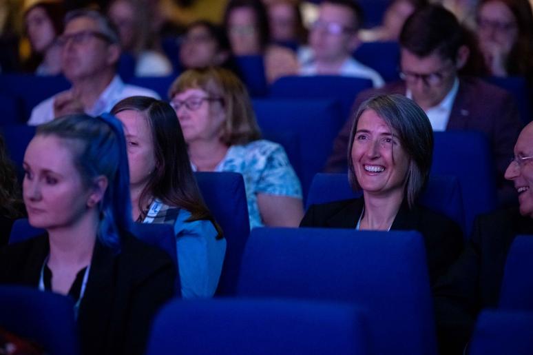 A group of event attendees watching a presentation