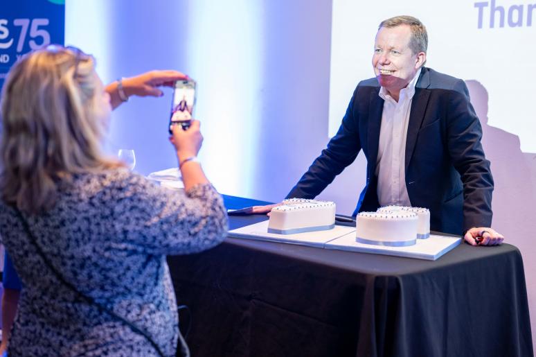 A speaker having his photo taken with the cake